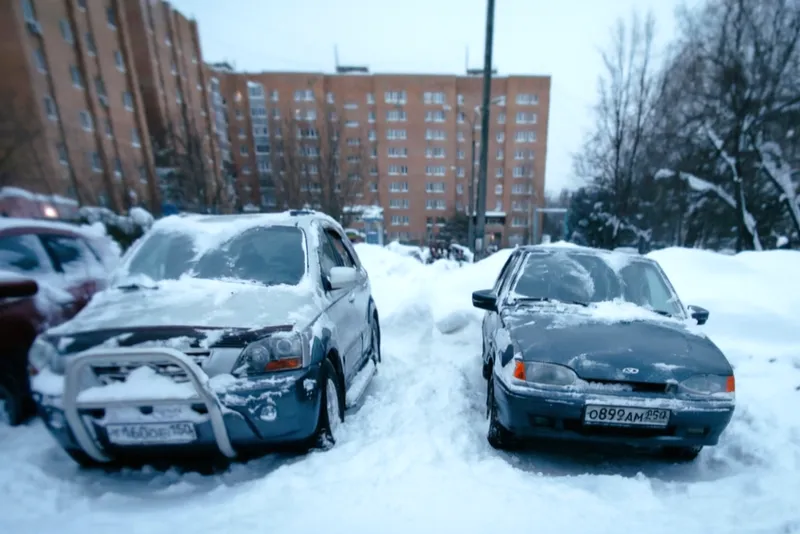 Очищенный от снега легковой автомобиль во дворе жилого дома в поселке Селятино