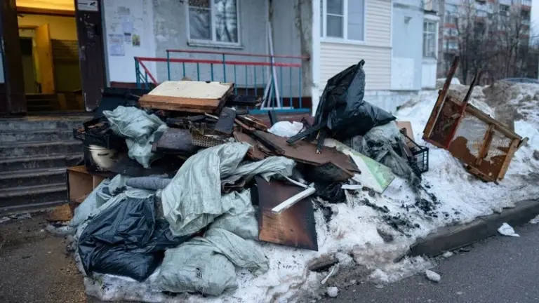 Куча строительного мусора и досок у входа в подъезд жилого дома на улице Пешехонова 4 в Наро-Фоминске после пожара, зима 2026 года
