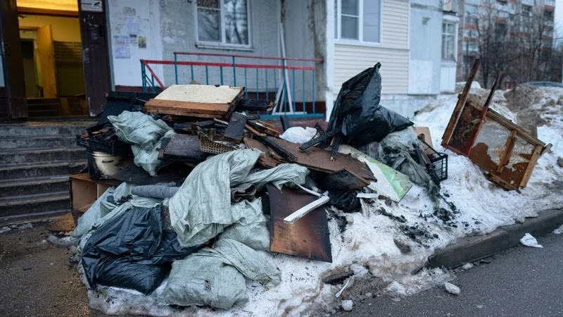 Куча строительного мусора и досок у входа в подъезд жилого дома на улице Пешехонова 4 в Наро-Фоминске после пожара, зима 2026 года